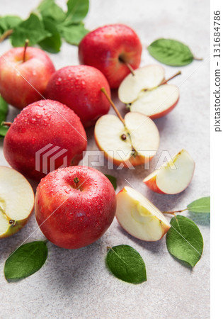 Fresh red apples with green leaves on grey background 131684786