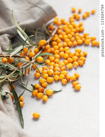 Sea buckthorn berries spilled on gray background 131684794