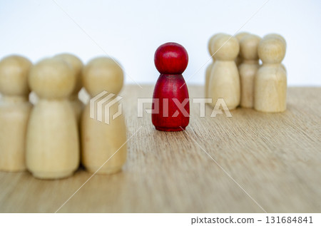 Peg wooden figures facing a red one showing respect and recognition of a leader. 131684841