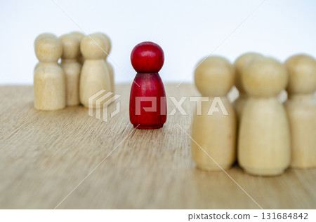 Group of beige wooden figures behind red figure symbolizing teamwork under leadership with customizable space for text. 131684842