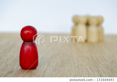 Red wooden pawn standing in front of blurred wooden symbolizing leadership with customizable space for text. Red wooden pawn standing in front of blurred wooden symbolizing leadership with customizable space for text. 131684843