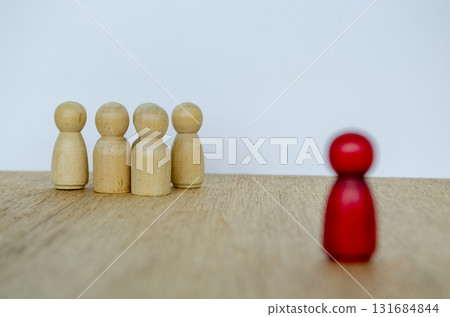 Blurred red wooden figure separated from group expressing independence and visionary leadership. Blurred red wooden figure separated from group expressing independence and visionary leadership. 131684844
