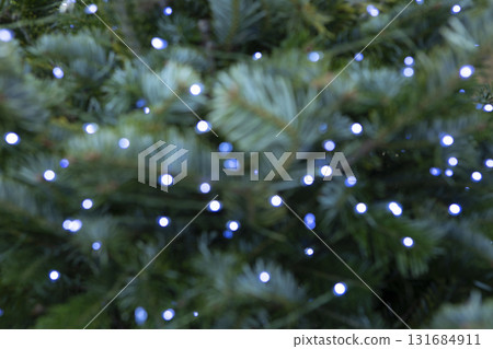 Garlands in bokeh style in background. Christmas lights and fir branches. Christmas texture for postcards. Garland with lights on the Christmas tree. Concept of New Year. Copy space. Garlands in bokeh style in background. Christmas lights and fir branches. Christmas texture for postcards. Garland with lights on the Christmas tree. Concept of New Year. Copy space. 131684911
