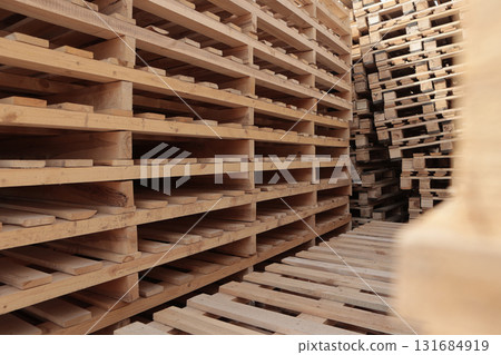 Wooden pallets. Stacking of wooden pallets. Concept of cargo transportation and shipping. Wooden pallets for transportation of building materials. 131684919