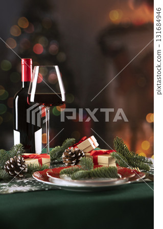 Red wine in glass on the New Year's table. Setting the table for the Christmas holiday. New Year. Red wine in glass on the New Year's table. Setting the table for the Christmas holiday. New Year. 131684946