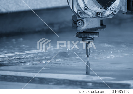 Close-up scene of multi-axis abrasive waterjet cutting machine cut the aluminum plate in the light blue scene Close-up scene of multi-axis abrasive waterjet cutting machine cut the aluminum plate in the light blue scene 131685102