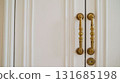 Golden door handles adorning white wooden door 131685198