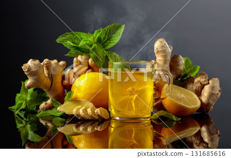 Ginger tea with lemon and mint on a black background. Ginger tea with lemon and mint on a black background. 131685616
