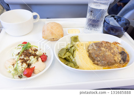 美味的短途商務艙機上餐食,包括肉漢堡和沙拉 美味的短途商務艙機上餐食,包括肉漢堡和沙拉 131685888