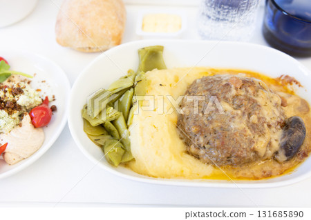 Delicious short-haul business class in-flight meal featuring meat hamburger and salad Delicious short-haul business class in-flight meal featuring meat hamburger and salad 131685890