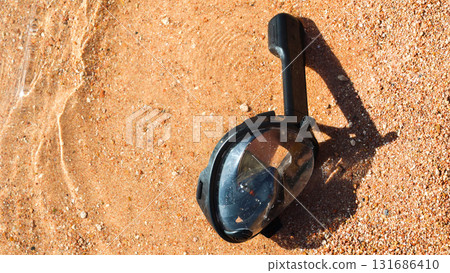 A snorkeling mask floats in the water on the sandy shore of the Red Sea, inviting adventurers to explore the underwater wonders A snorkeling mask floats in the water on the sandy shore of the Red Sea, inviting adventurers to explore the underwater wonders 131686410