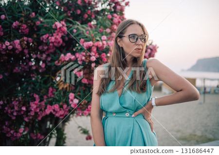 Elegant Woman Posing with Pink Flowers Outdoors Elegant Woman Posing with Pink Flowers Outdoors 131686447