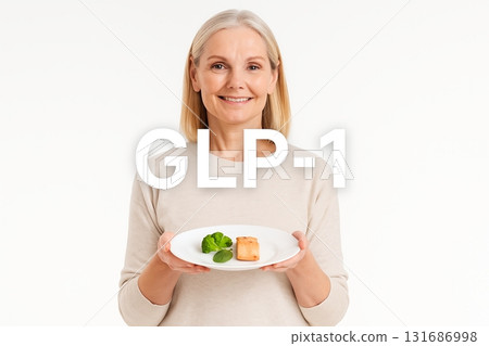 Middle-aged woman holding healthy food on plate with GLP1 concept 131686998