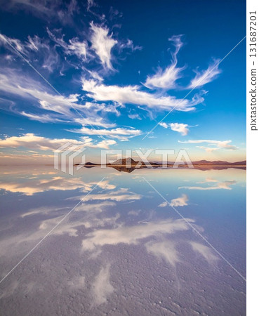 一片廣闊而狹長的鹽湖,湖面上完美地倒映著天空中的雲。 一片廣闊而狹長的鹽湖,湖面上完美地倒映著天空中的雲。 131687201