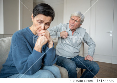 Enraged elderly man arguing and cursing at sad wife, showing intense anger and emotional outburst Enraged elderly man arguing and cursing at sad wife, showing intense anger and emotional outburst 131687289