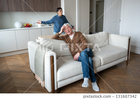 Agitated wife nags criticizes indifferent rude husband on couch. Household conflict marriage tension Agitated wife nags criticizes indifferent rude husband on couch. Household conflict marriage tension 131687342