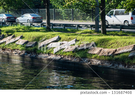 Riverbank infrastructure upkeep in city area. Granite embankment restoration on riverbank with slabs 131687408
