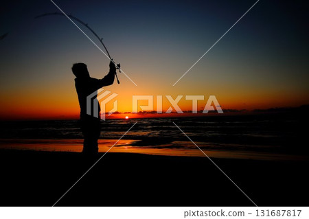 Silhouette of a man fishing at sunset 131687817