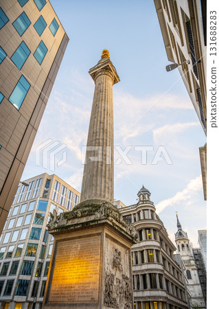 The Monument to the Great Fire of London rises between modern buildings, showcasing its historical significance. 131688283