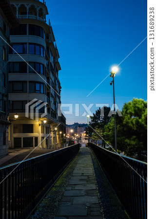 The old town of San Sebastian, Spain, before dawn: deserted cobblestone streets, streetlights and historic buildings The old town of San Sebastian, Spain, before dawn: deserted cobblestone streets, streetlights and historic buildings 131689238