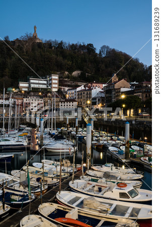 A port surrounded by historic buildings and lined with boats before dawn in the city of San Sebastian, Spain A port surrounded by historic buildings and lined with boats before dawn in the city of San Sebastian, Spain 131689239