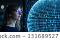 Woman with glasses looking at a large digital sphere with glowing blue lights in a dark environment 131689527