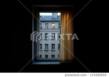 Late evening view through a window with a lit apartment in the distance 131689859