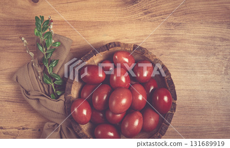 painted eggs in a wooden bowl, red, painted madder dye, powder from the roots of endro, with onion husks, top view, Easter, Georgia, 131689919