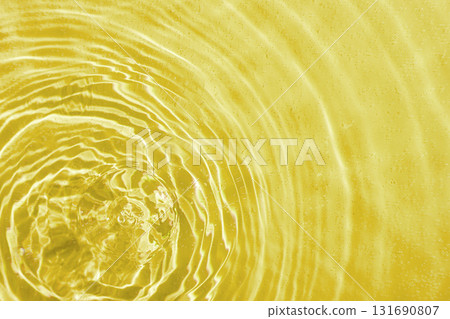 drops on water with circles on a yellow background 131690807