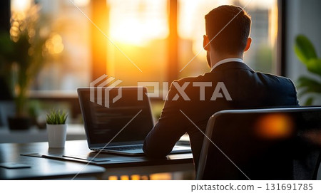 Back View of a Businessman Working on Laptop at Desk with Golden 131691785