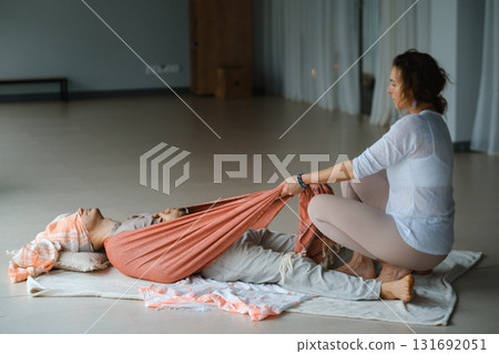 Wellness session for relaxation with guided stretching in a serene studio environment during a calm afternoon 131692051