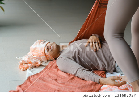 Individual receiving gentle support during a wellness session in a tranquil indoor setting with calming colors and natural light in the early afternoon Individual receiving gentle support during a wellness session in a tranquil indoor setting with calming colors and natural light in the early afternoon 131692057