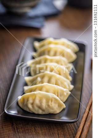 Traditional japanese gyoza dumplings on plate on wooden table. 131692111