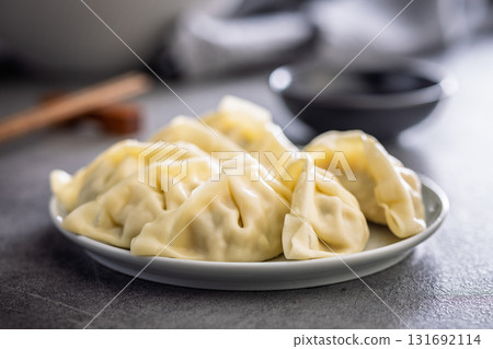 Traditional japanese gyoza dumplings and soy sauce on kitchen table. Traditional japanese gyoza dumplings and soy sauce on kitchen table. 131692114