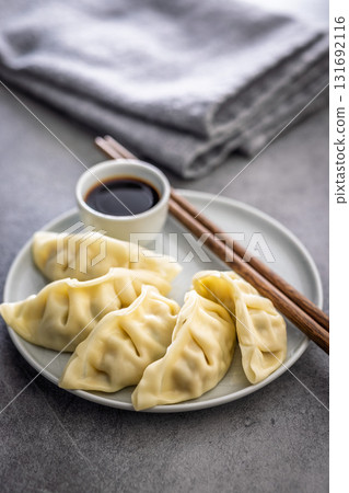 Traditional japanese gyoza dumplings and soy sauce on kitchen table. Traditional japanese gyoza dumplings and soy sauce on kitchen table. 131692116