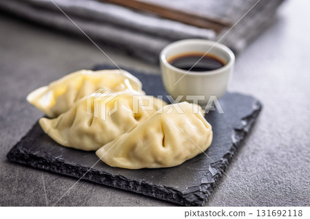 Traditional japanese gyoza dumplings and soy sauce on kitchen table. 131692118