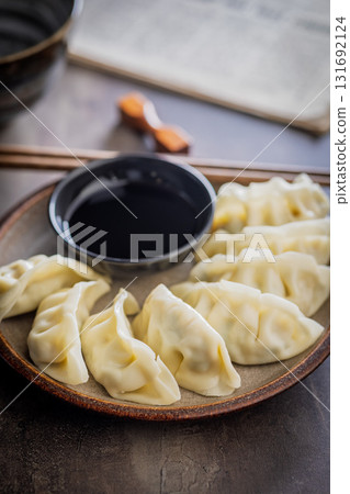 Traditional japanese gyoza dumplings and soy sauce on kitchen table. Traditional japanese gyoza dumplings and soy sauce on kitchen table. 131692124