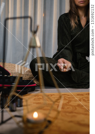 Meditation practice in a serene indoor setting during peaceful evening hours, showcasing a calm individual in a dark robe surrounded by mindfulness tools Meditation practice in a serene indoor setting during peaceful evening hours, showcasing a calm individual in a dark robe surrounded by mindfulness tools 131692132