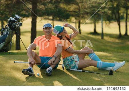Couple enjoys a relaxing moment on the golf course in sunny weather while playing golf and savoring quality time together 131692162