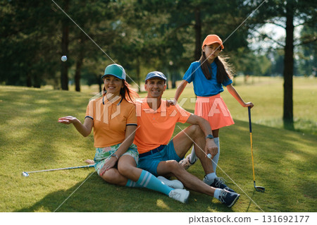 Family enjoys a fun day of golf wearing colorful outfits on a sunny afternoon at a lush golf course near the city Family enjoys a fun day of golf wearing colorful outfits on a sunny afternoon at a lush golf course near the city 131692177
