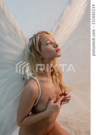 Beauty woman with angel wings in studio setting exuding elegance and grace 131692214