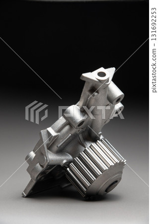 Top-quality parts for your car. Car maintenance. New water pump for a car's engine cooling system on a gray gradient background. Top-quality parts for your car. Car maintenance. New water pump for a car's engine cooling system on a gray gradient background. 131692253