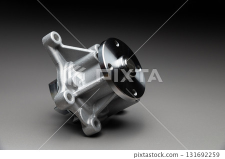 Top-quality parts for your car. Car maintenance. New water pump for a car's engine cooling system on a gray gradient background. 131692259