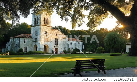 Mediterranean-style building with bell tower bathed in golden su 131692381