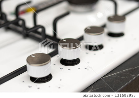 Close-up of modern gas stove flame control knobs. Close-up of modern gas stove flame control knobs. 131692953
