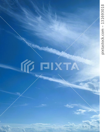 Contrails and cirrus clouds stretching across the blue sky Contrails and cirrus clouds stretching across the blue sky 131693018