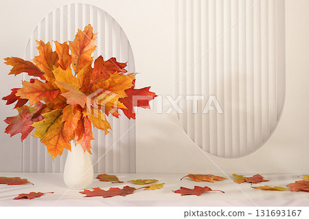 Autumn abstract composition with maple leaves in a vase on an elegant modern kitchen table, still life and Thanksgiving concept, seasonal background and banner for screen, greeting card. 131693167