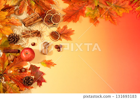 Autumn banner or screensaver, greeting card, abstract composition with maple leaves, pine cones, nuts, cinnamon, star anise and dried oranges, still life and Thanksgiving concept. 131693183
