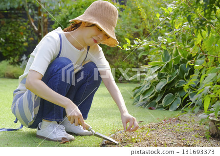 A woman in an apron tending to her garden 131693373