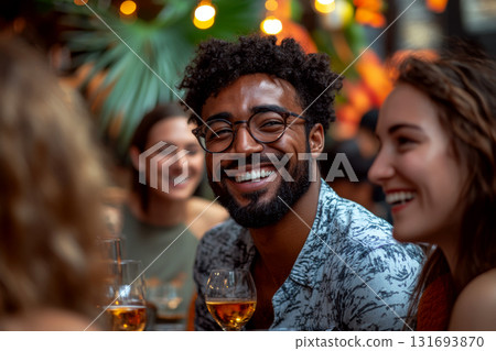 Smiling person with glasses enjoying a gathering with friends, holding a drink. Concept of joy and socializing. For lifestyle and social event photography. Smiling person with glasses enjoying a gathering with friends, holding a drink. Concept of joy and socializing. For lifestyle and social event photography. 131693870